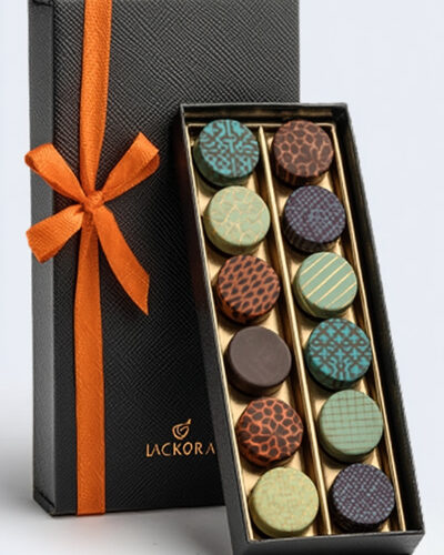 Caja rectangular de bombones con diseño elegante, chocolates decorados con patrones geométricos, lazo naranja y presentación de alta gama